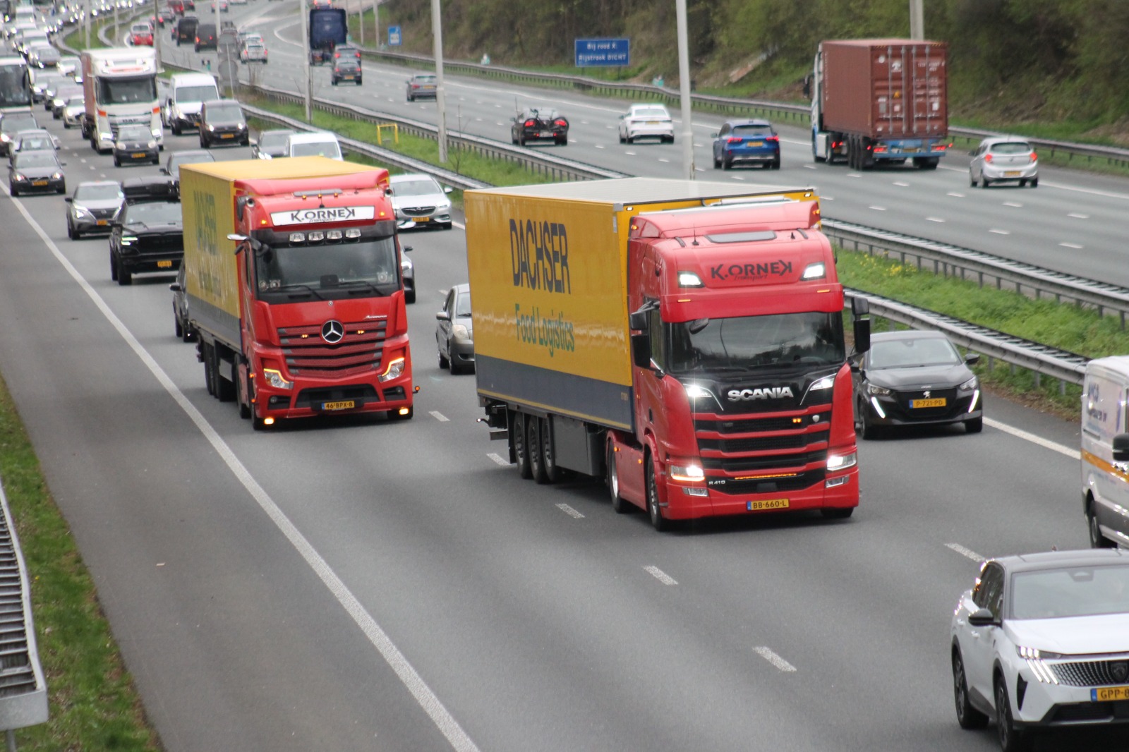 Twee rode vrachtwagens van K. Ornek Transport onderweg op de snelweg